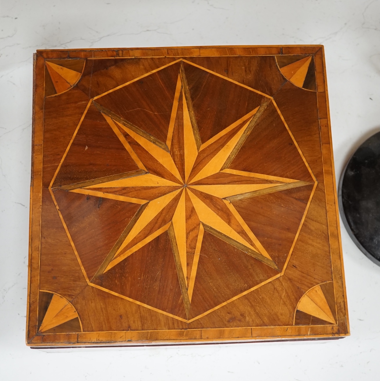 An early 19th century wood parquetry specimen box decorated with a star design top, 26cm wide, 10cm high, 26.5cm deep. Condition - fair